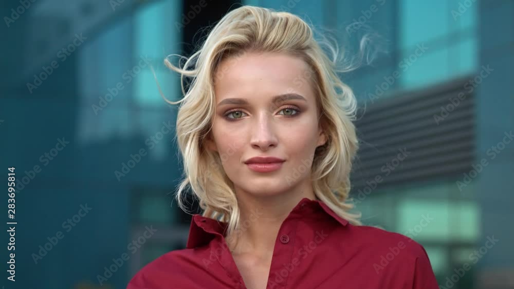 Young beautiful woman looks in the camera in the city Young beautiful woman looks in the camera in the city