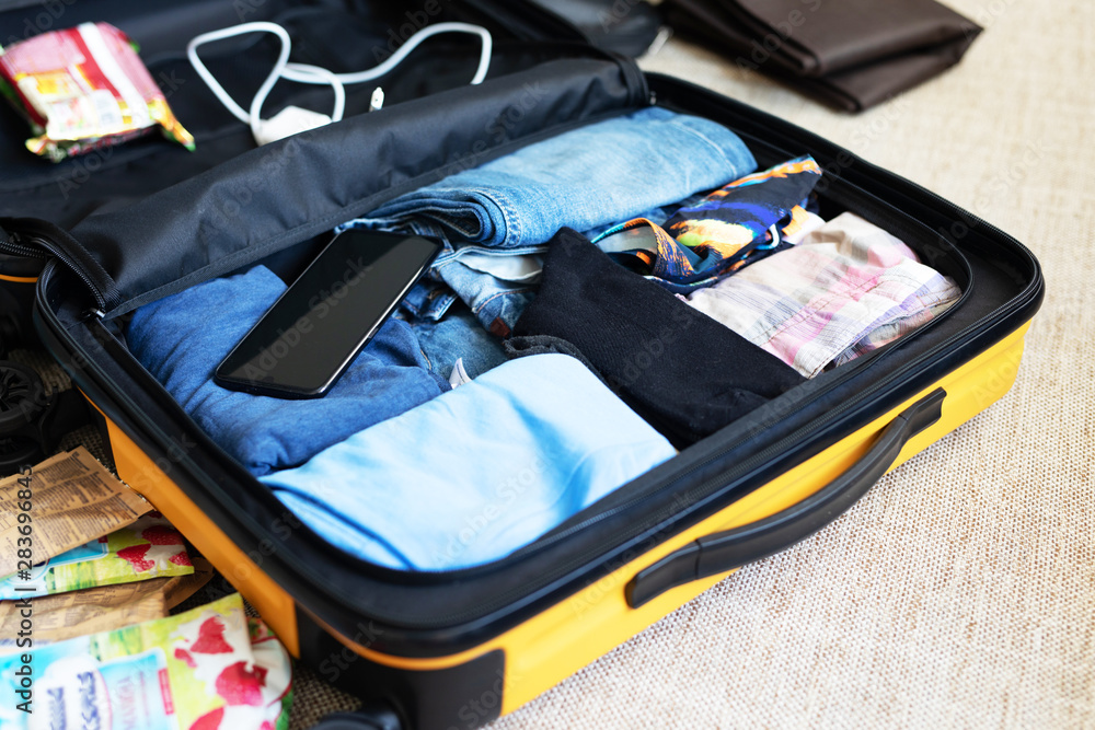 An open suitcase with men's clothing, packed for a business trip or travel  Stock Photo | Adobe Stock