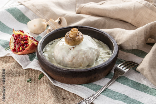 baked chicken breast with champignon mushrooms and cream sauce in kezi pan on tablecloth photo