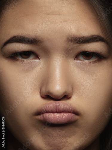 Close up portrait of young and emotional chinese woman. Highly detail photoshot of female model with well-kept skin and bright facial expression. Concept of human emotions. Looks sad, offended. © master1305
