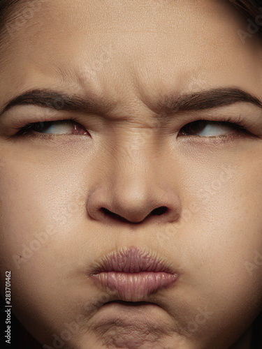 Close up portrait of young and emotional chinese woman. Highly detail photoshot of female model with well-kept skin and bright facial expression. Concept of human emotions. Angry, blowing, distent. photo