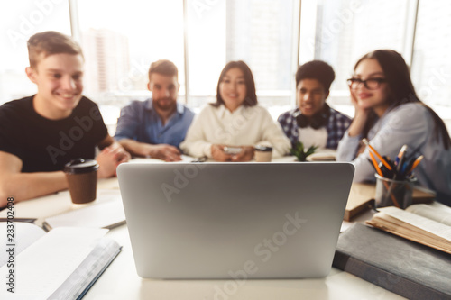 Diverse students studying for school assignment  using laptop