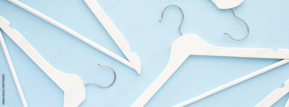 White wooden hangers on blue background Stock Photo | Adobe Stock
