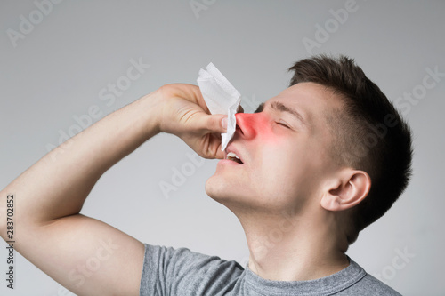 Young man with nosebleed or epistaxis, black and white photo photo
