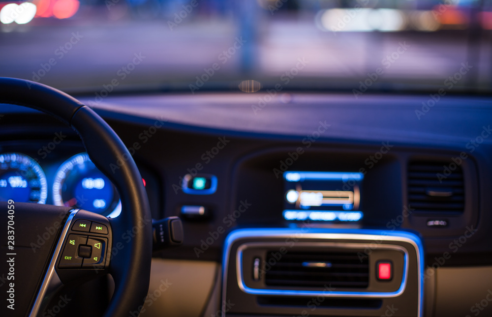 Interior of a modern car at night in a city (shallow DOF; color toned image)