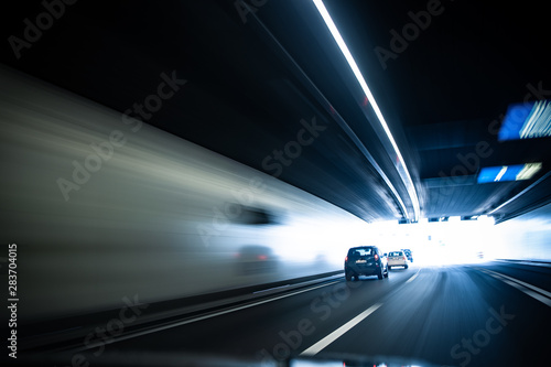 Cars on a highway going through a long modern tunnel (motion blurred image; color toned image)