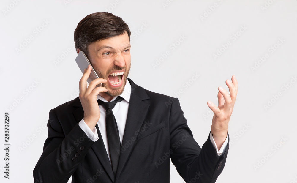 Angry Businessman Shouting Talking On Cellphone Over White Background Angry Businessman Shouting Talking On Cellphone Over White Background