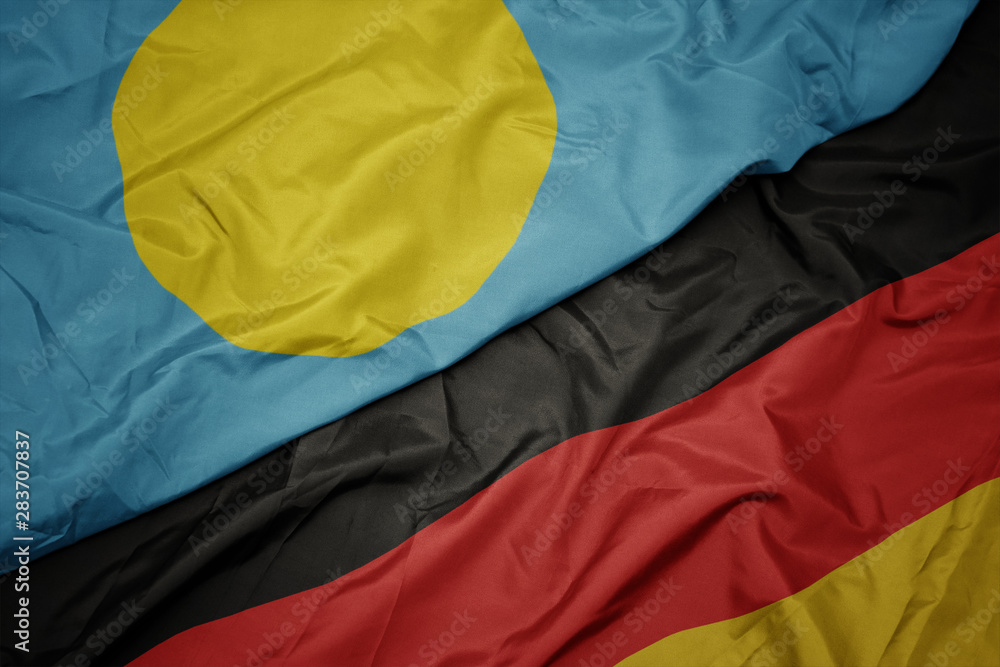 waving colorful flag of germany and national flag of Palau. waving colorful flag of germany and national flag of Palau.