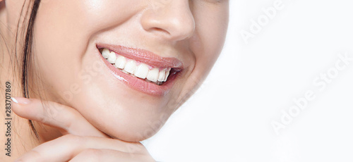 Womanl with a beautiful smile and healthy teeth on a white background close-up