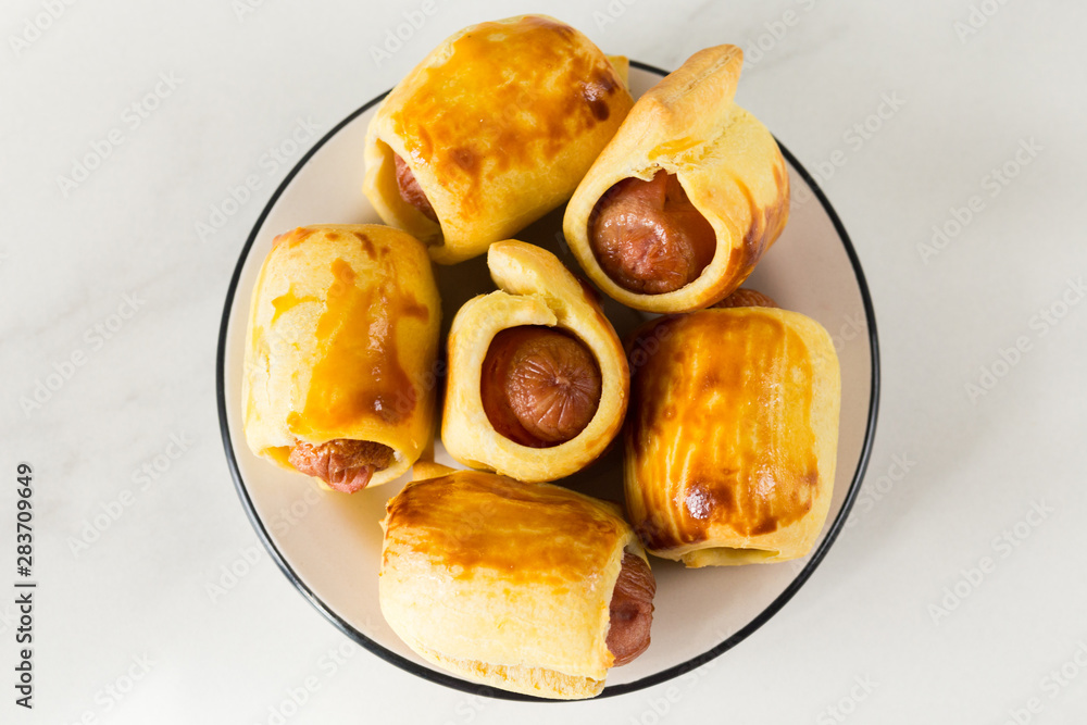 Pastry wrapped sausage rolls, fried sausage pies in dough. Junk food