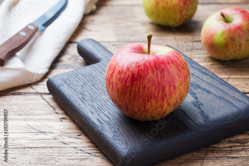 Red apples on a wooden table. Apples cut into slices. Copy space.