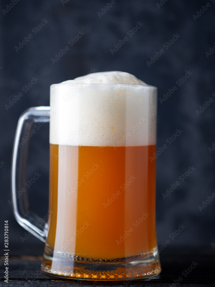 Beer mug unfiltered wheat beer close-up with a large foam cap