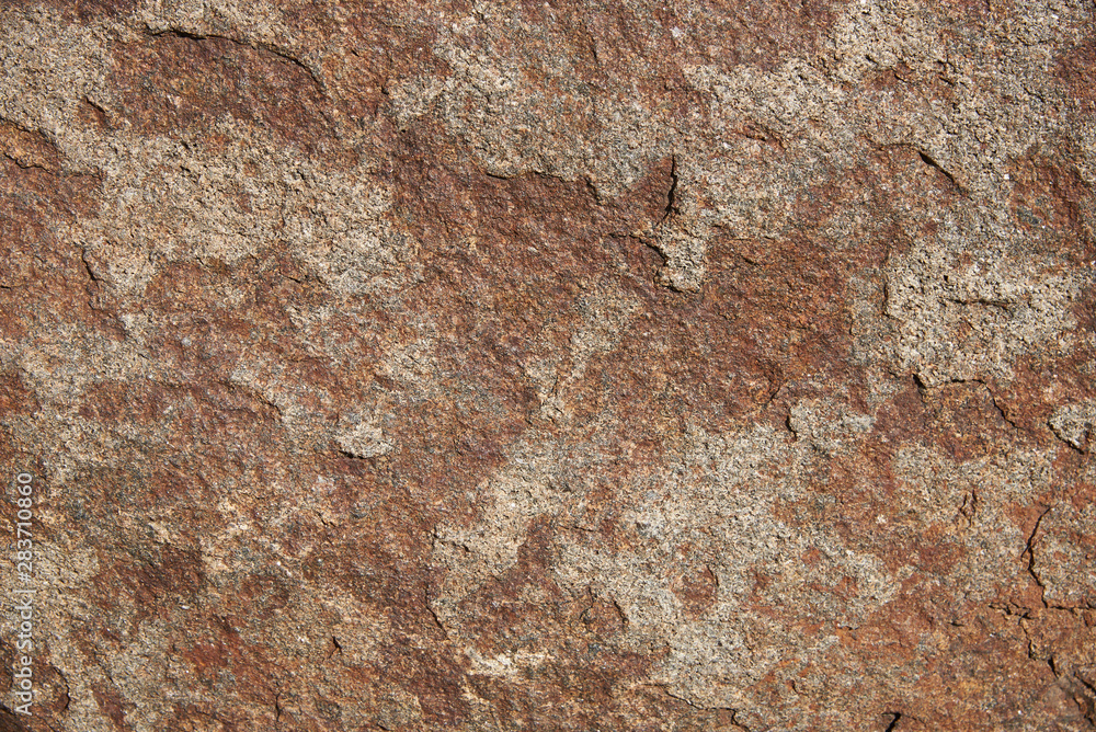 A fragment of the surface of a stone made of granite. Background, texture A fragment of the surface of a stone made of granite. Background, texture