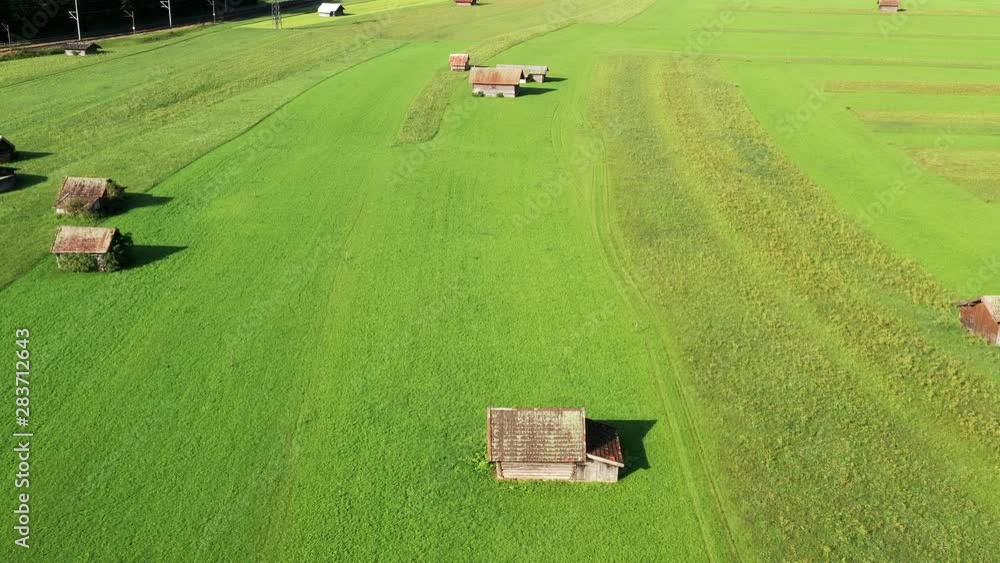 Aerial view of a green meadow with small sheds and barns Aerial view of a green meadow with small sheds and barns