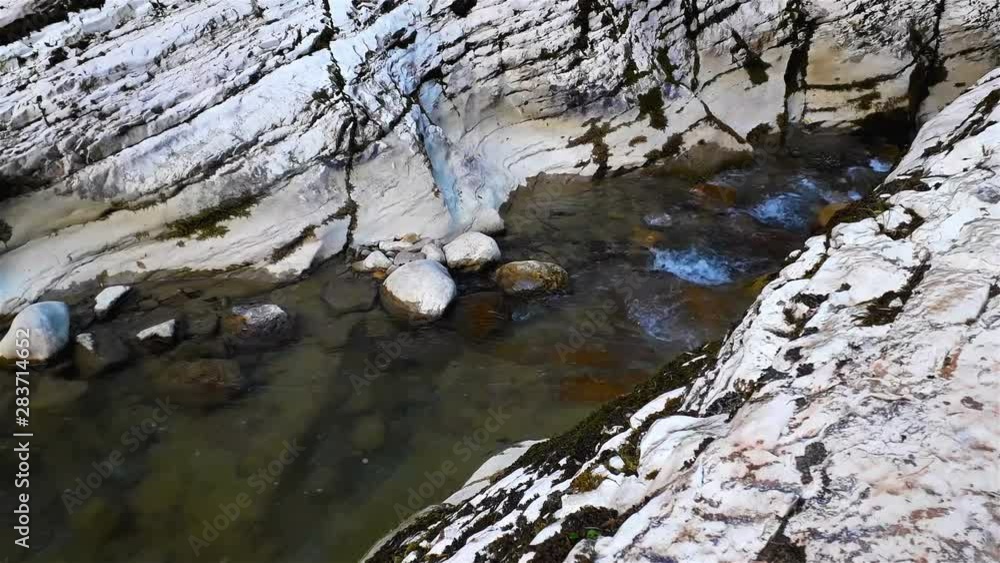 Mountain river at summer sunny day in ravine, water among stones Mountain river at summer sunny day in ravine, water among stones
