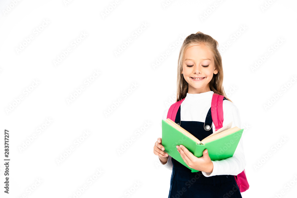 adorable schoolgirl smiling while reading books isolated on white adorable schoolgirl smiling while reading books isolated on white