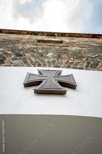 Obraz na plátně Eisernes Kreuz an Wand über einem Soldatendenkmal