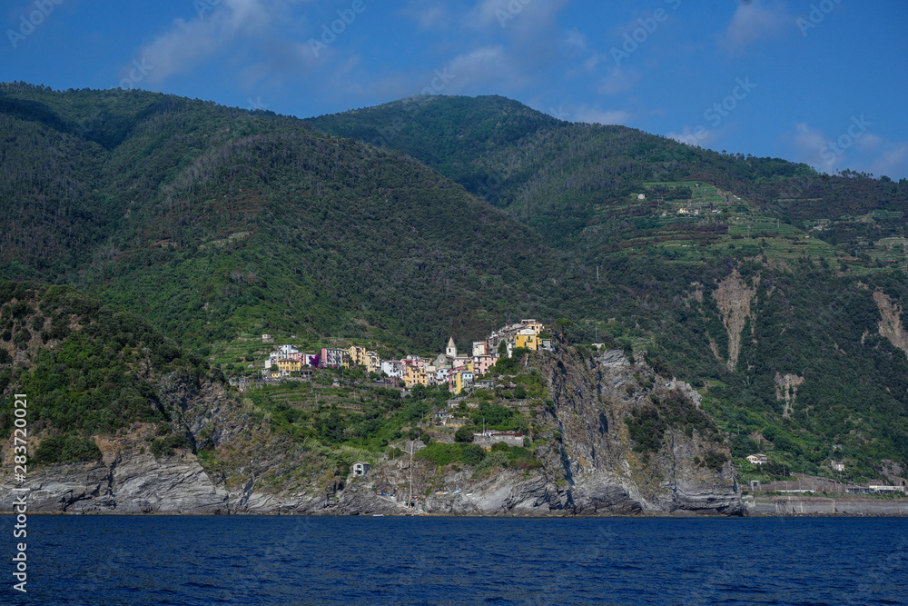 Corniglia with colorful houses, a Cinque Terra mountain village and tourist attraction on the steep coast of the Mediterranean sea in Liguria, Italy, copy space