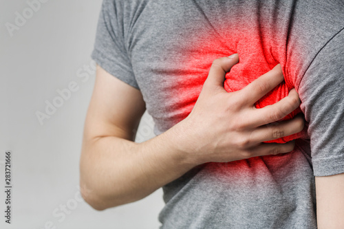 Caucasian man having heart ache, holding hand on chest