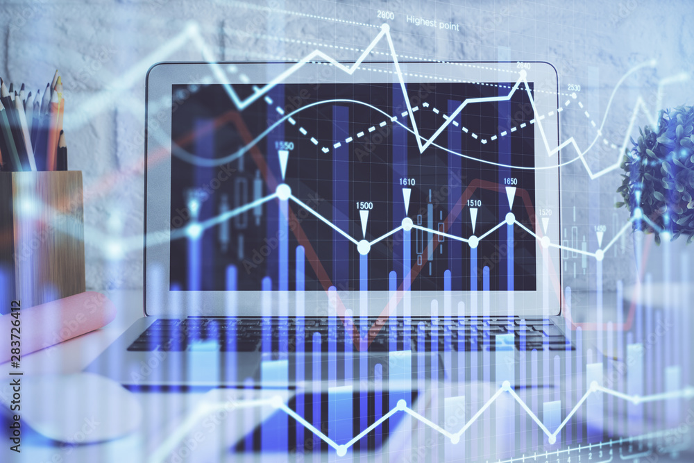 Forex Chart hologram on table with computer background. Double exposure. Concept of financial markets. Forex Chart hologram on table with computer background. Double exposure. Concept of financial markets.