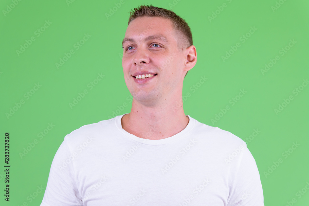 Face of happy young man thinking and looking away Face of happy young man thinking and looking away