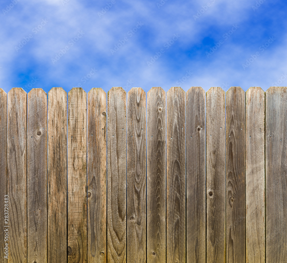 Fototapeta premium Rustic wooden fence with blue sky and clouds