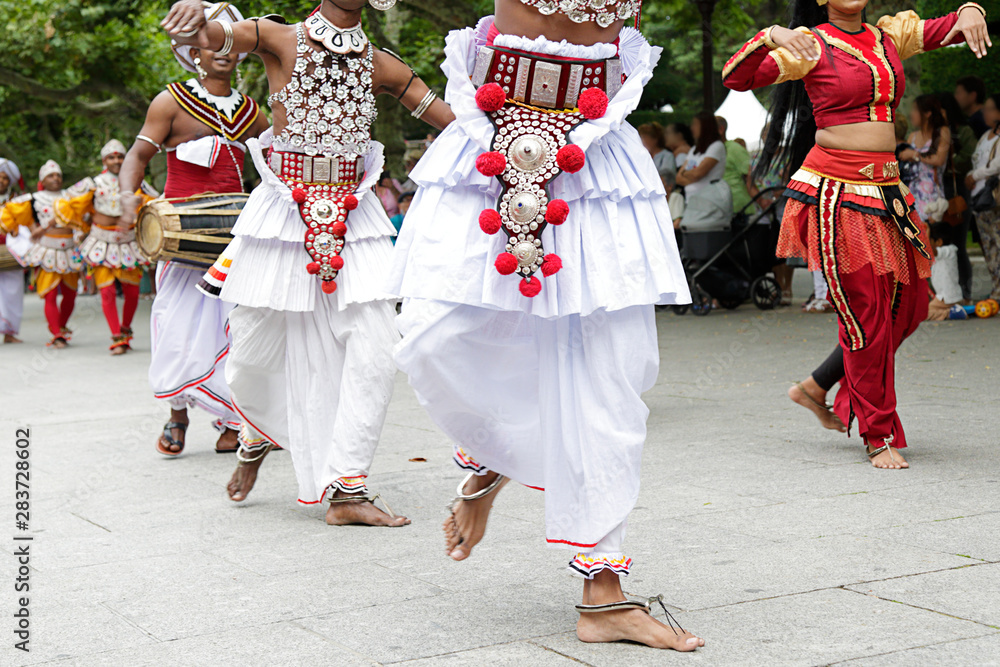 Dancers dancing and wearing one of the traditional folk costume from Sri Lanka.