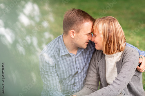 Happy young couple hugging and laughing together in the park