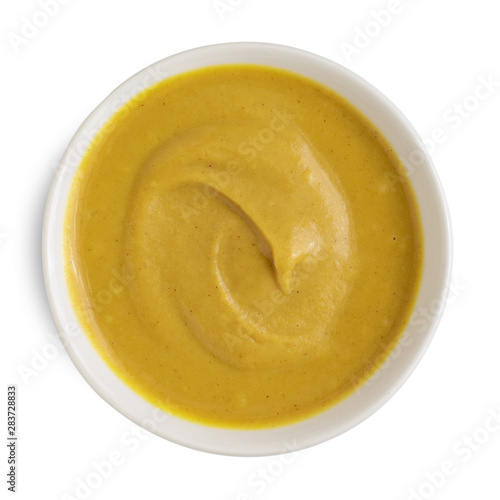 Mustard sauce in white ceramic bowl isolated on white background. Top view