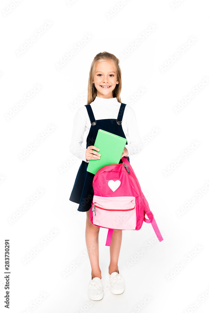 full length view of cute schoolgirl holding backpack and book on white background full length view of cute schoolgirl holding backpack and book on white background