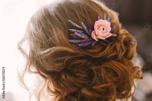 Modern bridal fashion. Closeup of bride's hairstyle with a beautiful flower decoration.