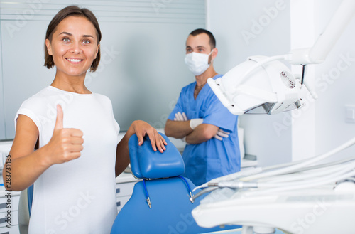 woman is standing satisfied after treatment in dental office