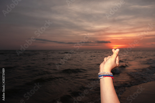 Mini heart hand Signs made by women tourists on sea beach During the sunset . Symbolic of Korea can be used for love and Happy moments .