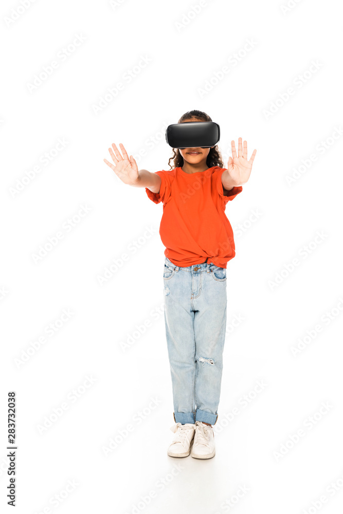 full length view of african american child standing with outstretched hands while using virtual reality headset on white background full length view of african american child standing with outstretched hands while using virtual reality headset on white background