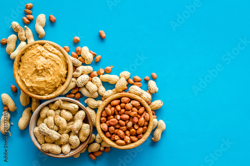nuts in bowl for peanut butter for cooking breakfast at home on blue background top view mock-up