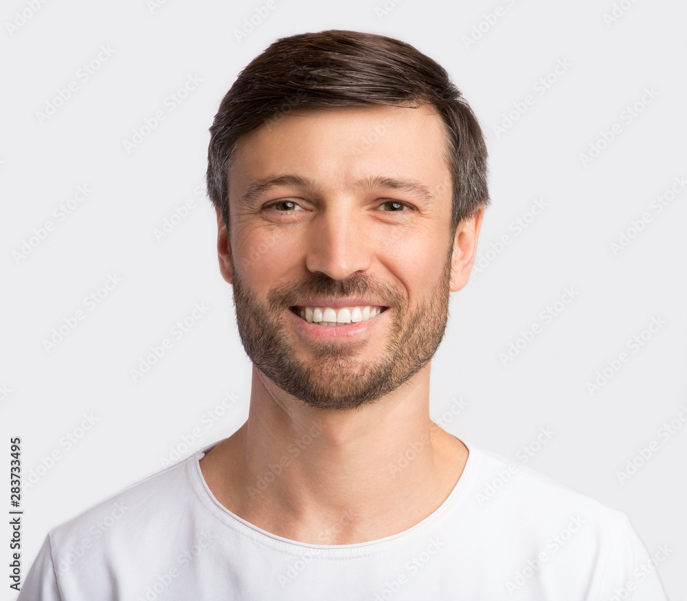 Positive Charismatic Man Smiling At Camera Over White Background Positive Charismatic Man Smiling At Camera Over White Background