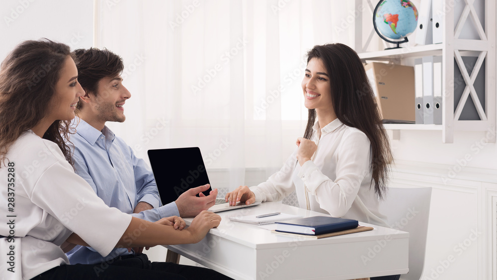 Young couple came to travel agency, choosing trip Young couple came to travel agency, choosing trip