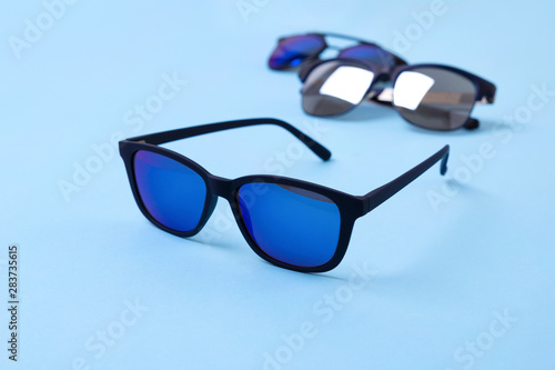 Various stylish sunglasses on blue creative background