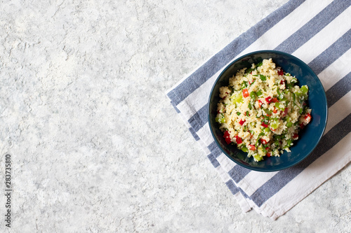 Tabbouleh salad with couscous, parsley, lemon, tomato, olive oil. Levantine vegetarian salad. Lebanese, arabic cuisine. Light background. Top view. Space for text