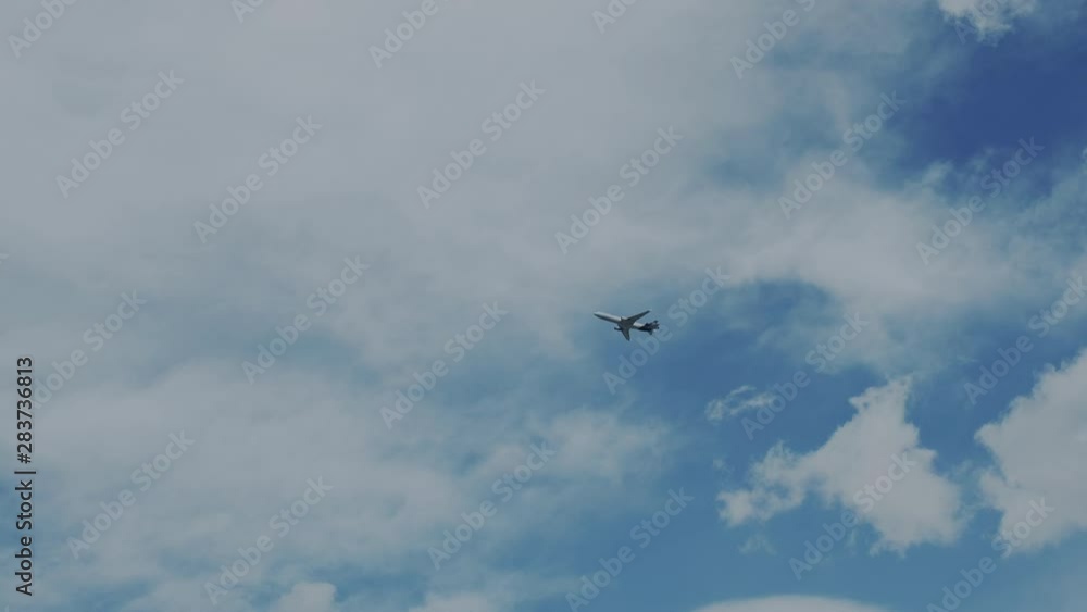 Passenger civilian plane flies against a blue sky with clouds. Aircraft flight, flying overhead on sunny day, takes off. Aviation, modern and speed vehicles. Passenger civilian plane flies against a blue sky with clouds. Aircraft flight, flying overhead on sunny day, takes off. Aviation, modern and speed vehicles.