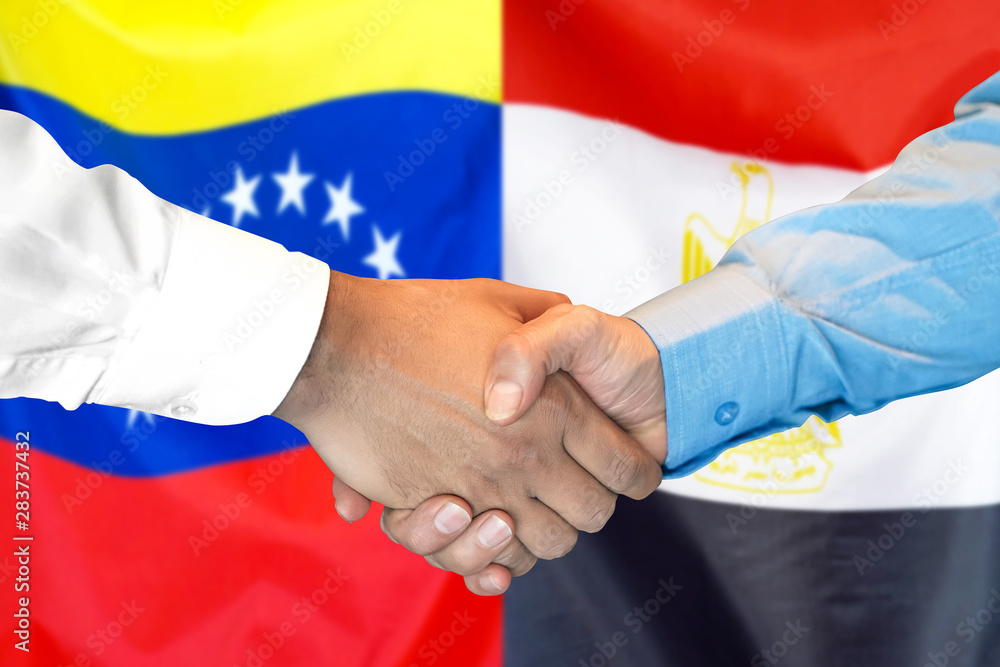 Handshake on Venezuela and Egypt flag background.