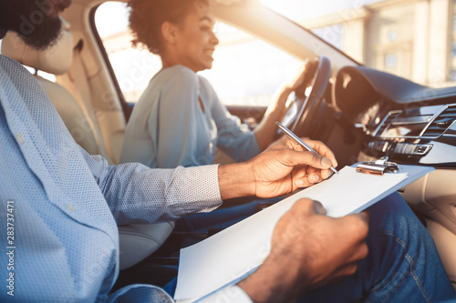 Tableau sur toile Driving test. Young woman driving car feeling inexperienced