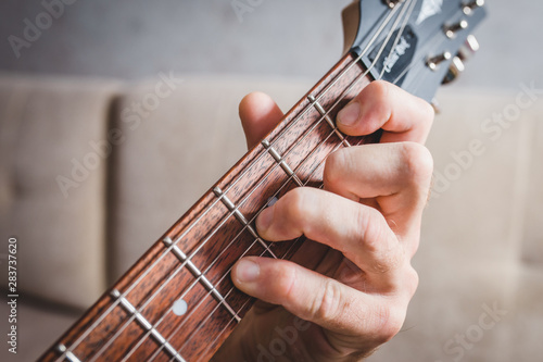 Ebm chord - close-up male Caucasian hand takes a chord on a 6 string guitar