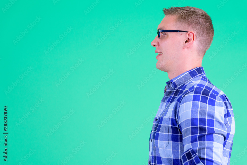 Closeup profile view of happy young hipster man smiling Closeup profile view of happy young hipster man smiling