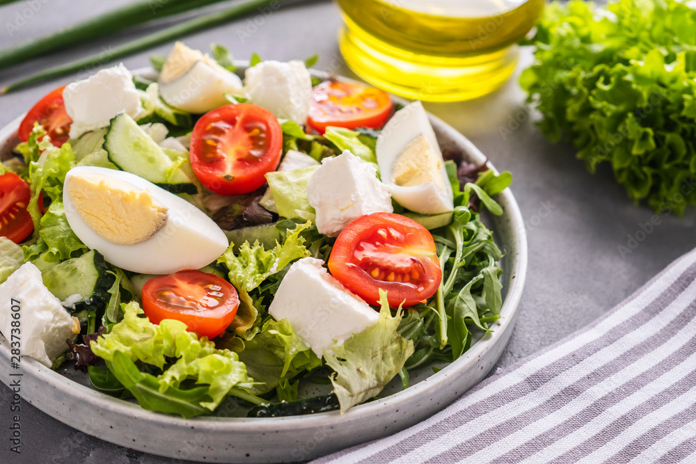 Diet salad with eggs, tomatoes, cheese and mixed greens. Copy space