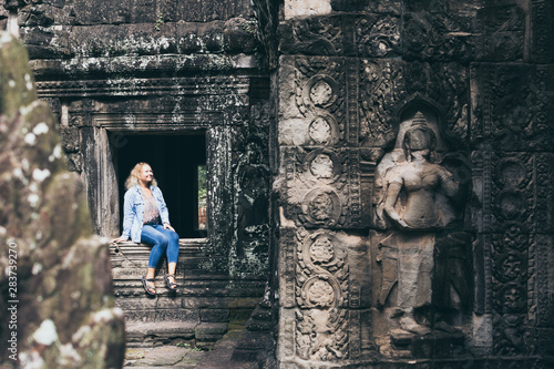 Caucasian blonde woman discovering the ruins of Angkor Wat temple complex in Siem Reap, Cambodia © oleksii.leonov