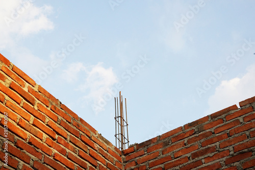 Unfinished brick wall with iron frame and great blue sky