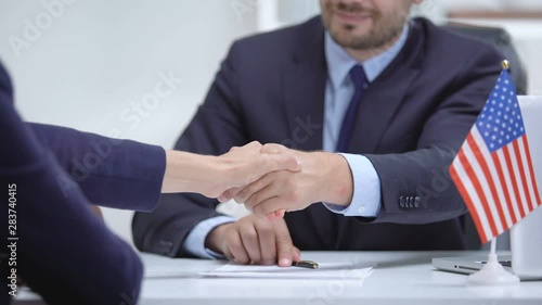 US official signing contract for international cooperation, shaking partner hand photo