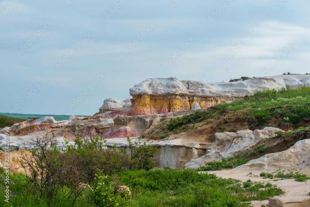 Landscape of pink, yellow and white stone formations against a cloudy sky at Interpretive Paint Mines in Colorado