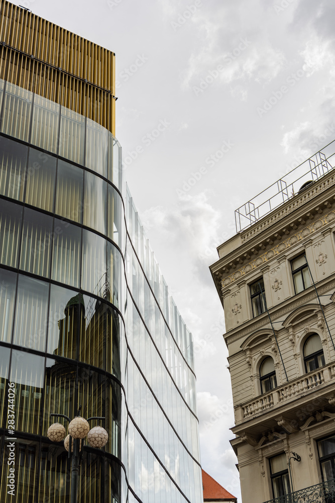 Obraz premium Neighborhood of modern and old buildings in the historical center of Prague, rainy sunny autumn